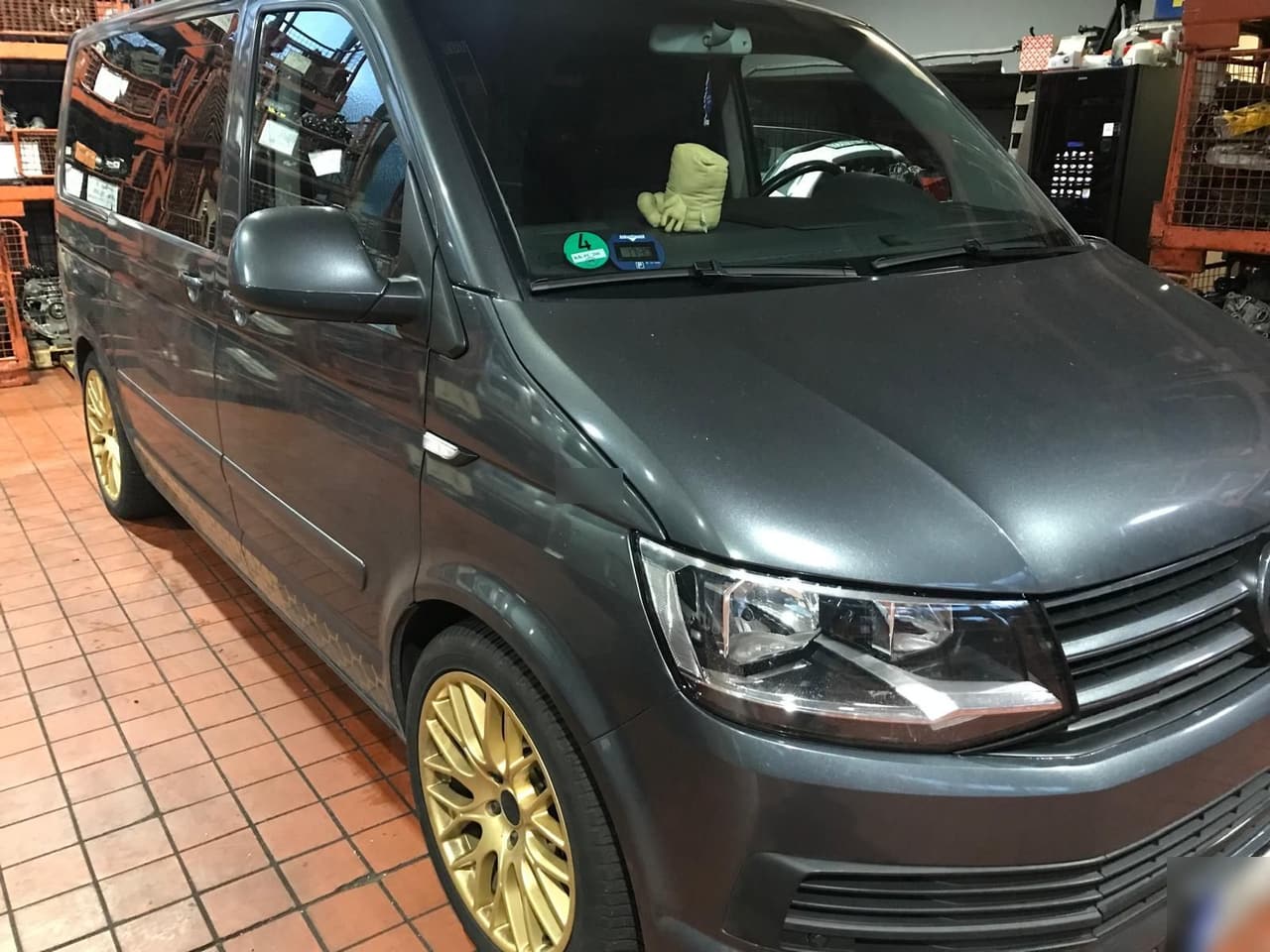 Grauer VW T6 mit goldenen Felgen in der Werkstatthalle